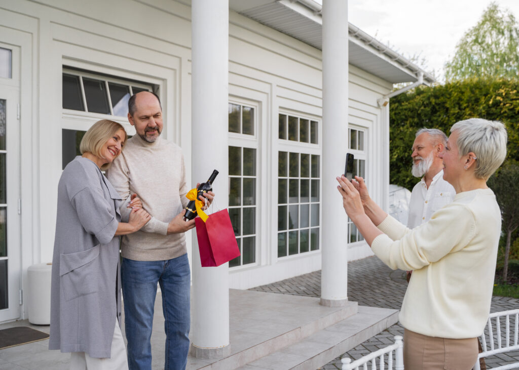 Elder parent taking photo of couple at new house